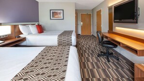 A hotel room with two beds, a desk, a chair, a TV, and a door. - Microtel Inn & Suites by Wyndham Pittsburgh Airport (Pittsburgh)
