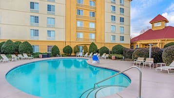 Una piscina al aire libre de temporada, sombrillas