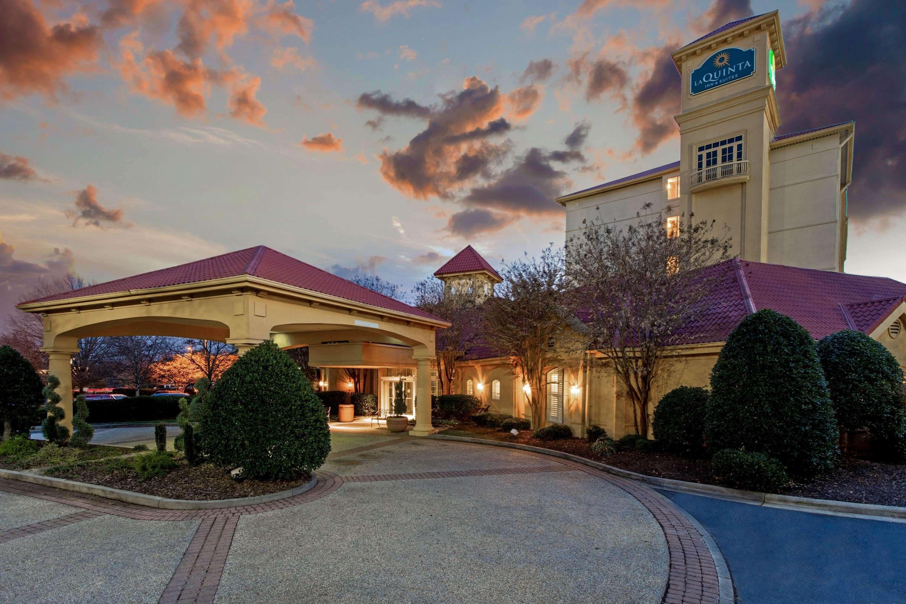 A hotel with a prominent tower, a covered entrance, and well-maintained landscaping.