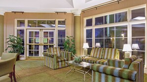 A living room with striped sofas, a coffee table, and a dining area with a chair and table.