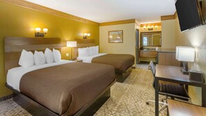 A hotel room with two beds, a desk, a chair, a TV, and a bathroom visible in the background. - Best Western Rivers Edge (Red River)