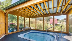 A hot tub in a covered outdoor area with a view of a mountain and a wooden deck. - Best Western Rivers Edge (Red River)