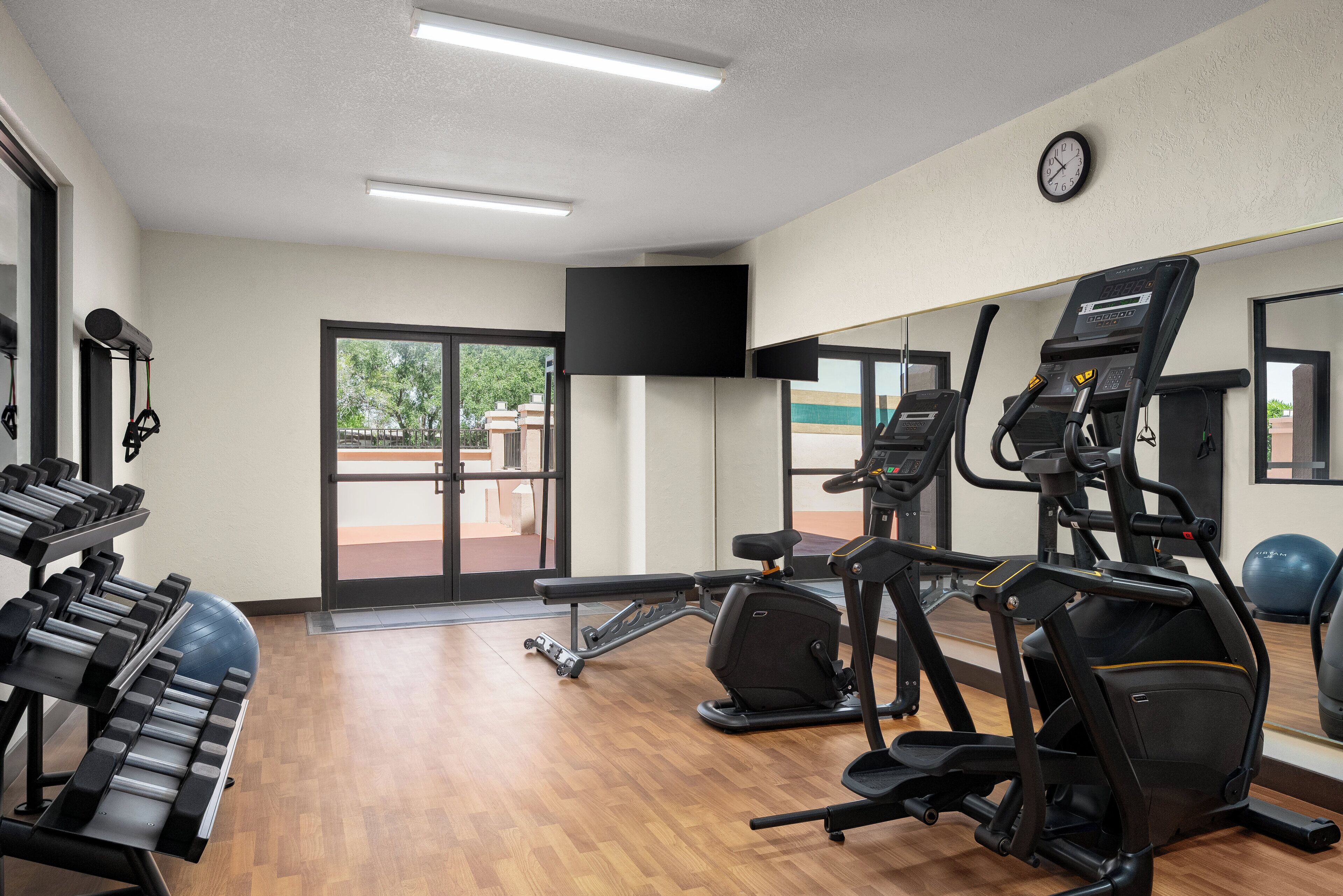 Een fitnessruimte met loopbanden, hometrainers en krachtapparaten.