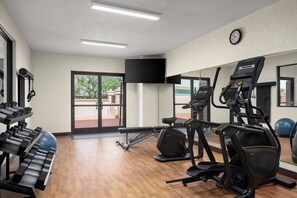 Een fitnessruimte met loopbanden, hometrainers en krachtapparaten.