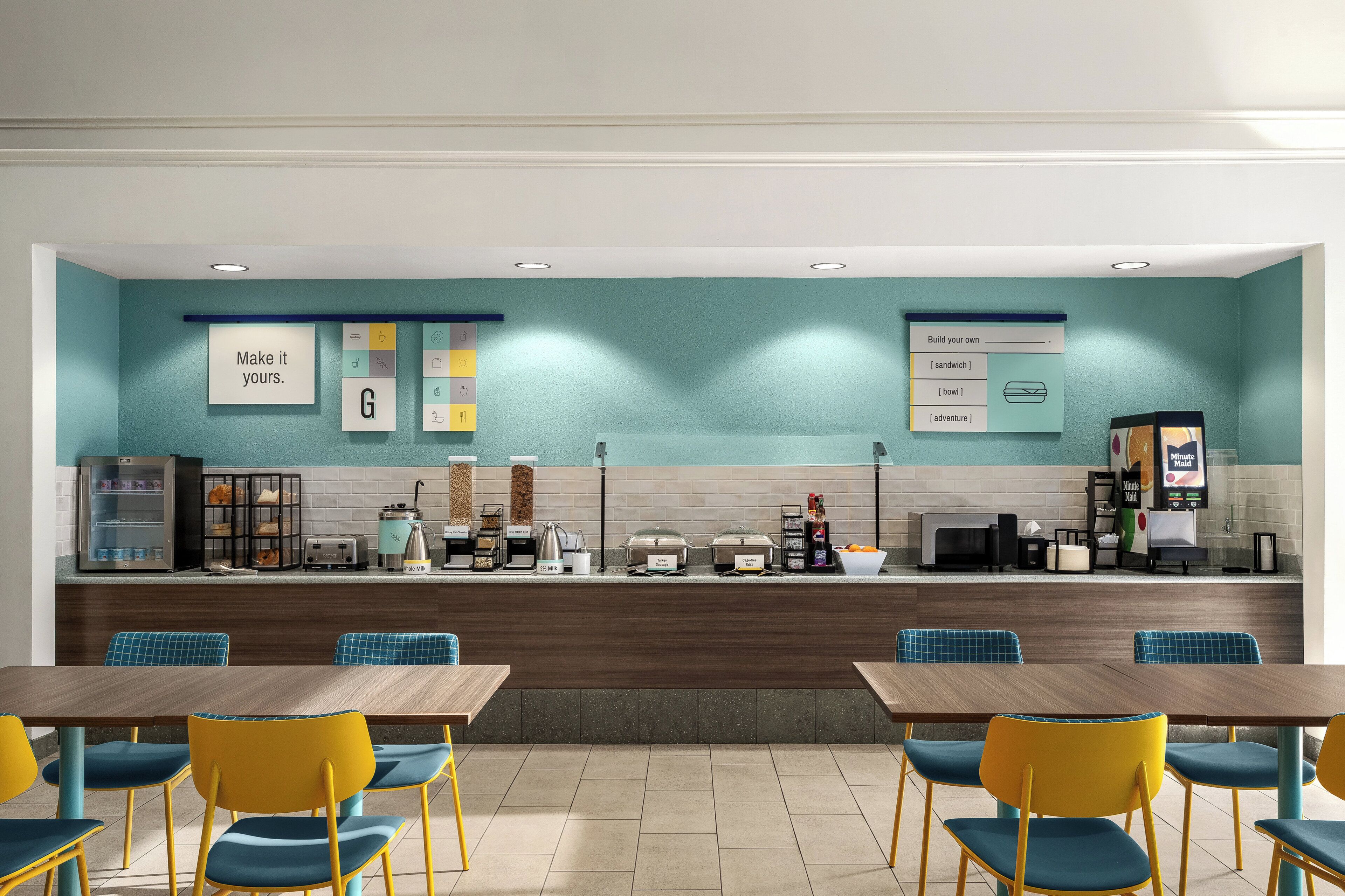 Een modern café met een balie, een zitgedeelte en diverse stations voor eten en drinken.
