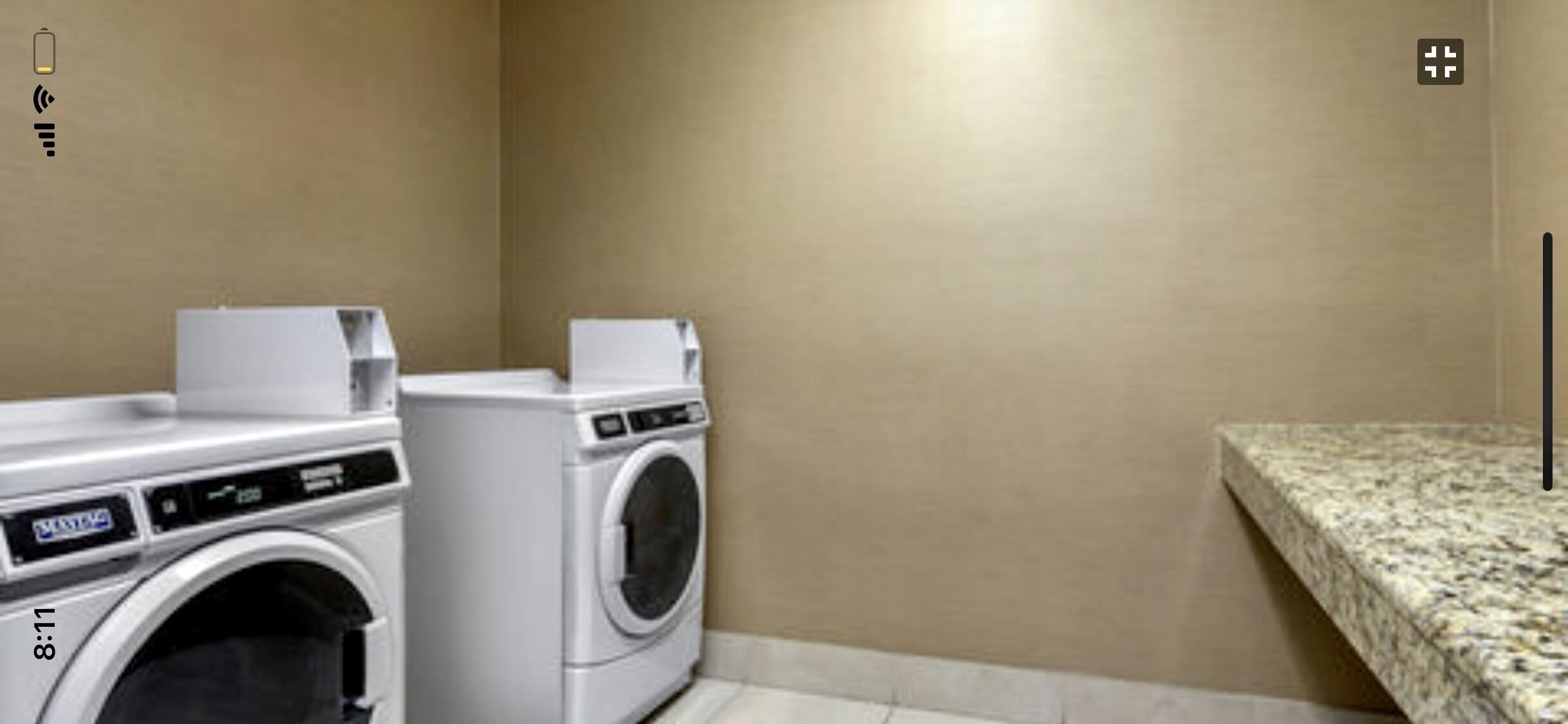 A laundry area with a washing machine and dryer, a countertop, and a wall-mounted light.