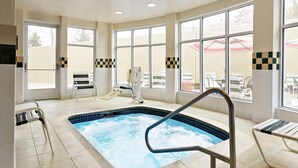 An indoor swimming pool with a view of outdoor seating and a slide. - Hilton Garden Inn Shelton (Shelton)