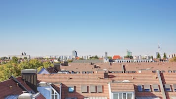 A cityscape with red-tiled rooftops and a variety of buildings, including a prominent tower.