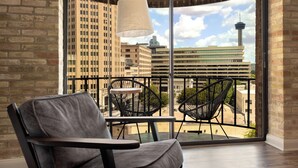 A balcony with a view of a cityscape, including a tower and several buildings.