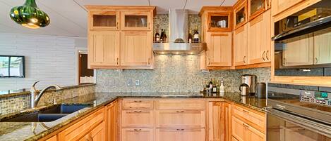 A kitchen with wooden cabinets, a stainless steel sink, and a built-in oven.
