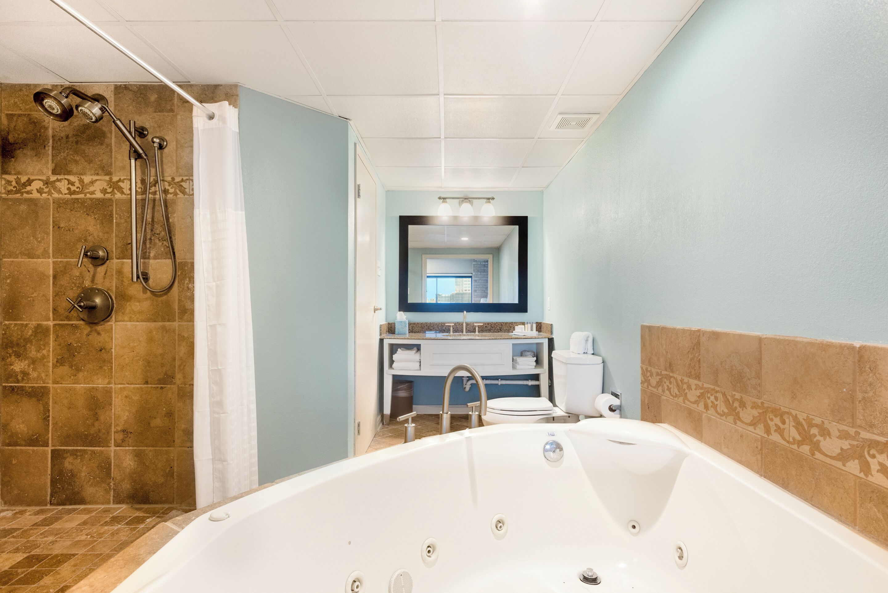 Un baño con ducha, bañera, inodoro y lavamanos.
