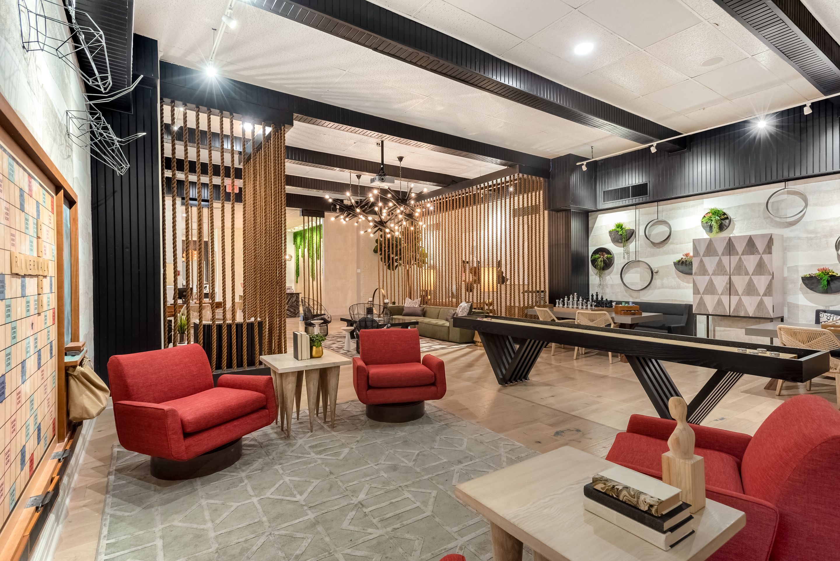 Um interior moderno com mesa de bilhar, cadeiras vermelhas e espa ço para jogos.