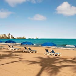 On the beach, white sand, sun-loungers, beach umbrellas
