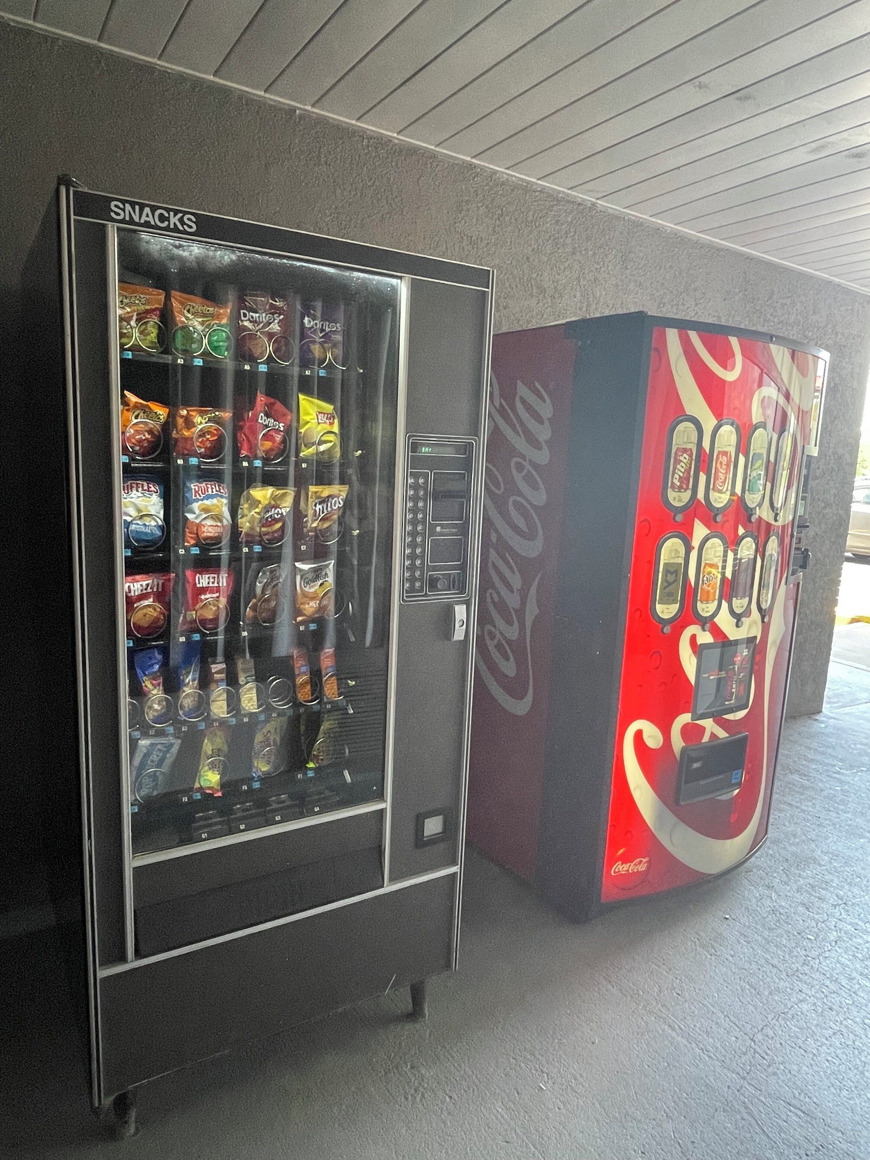 Un distributeur automatique de collations et un autre de boissons, notamment du Coca-Cola.