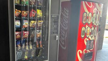 Un distributeur automatique de collations et un autre de boissons, notamment du Coca-Cola.