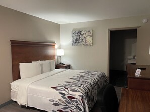 A hotel room with a bed, a nightstand, a lamp, a desk, and a chair. - Red Roof Inn LaGrange (LaGrange)