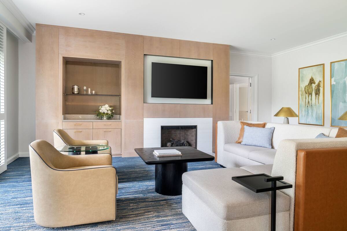 Una sala moderna con televisión de pantalla plana, chimenea y sofá.