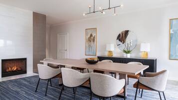 Un comedor moderno con una mesa larga, seis sillas, una chimenea y un candelabro.