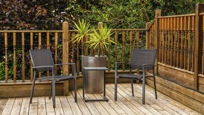 A wooden deck with two chairs and a large planter. - ibis Styles London Gloucester Road (London)