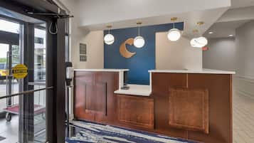 Una recepción con pared azul, decoración de luna creciente y luces colgantes.