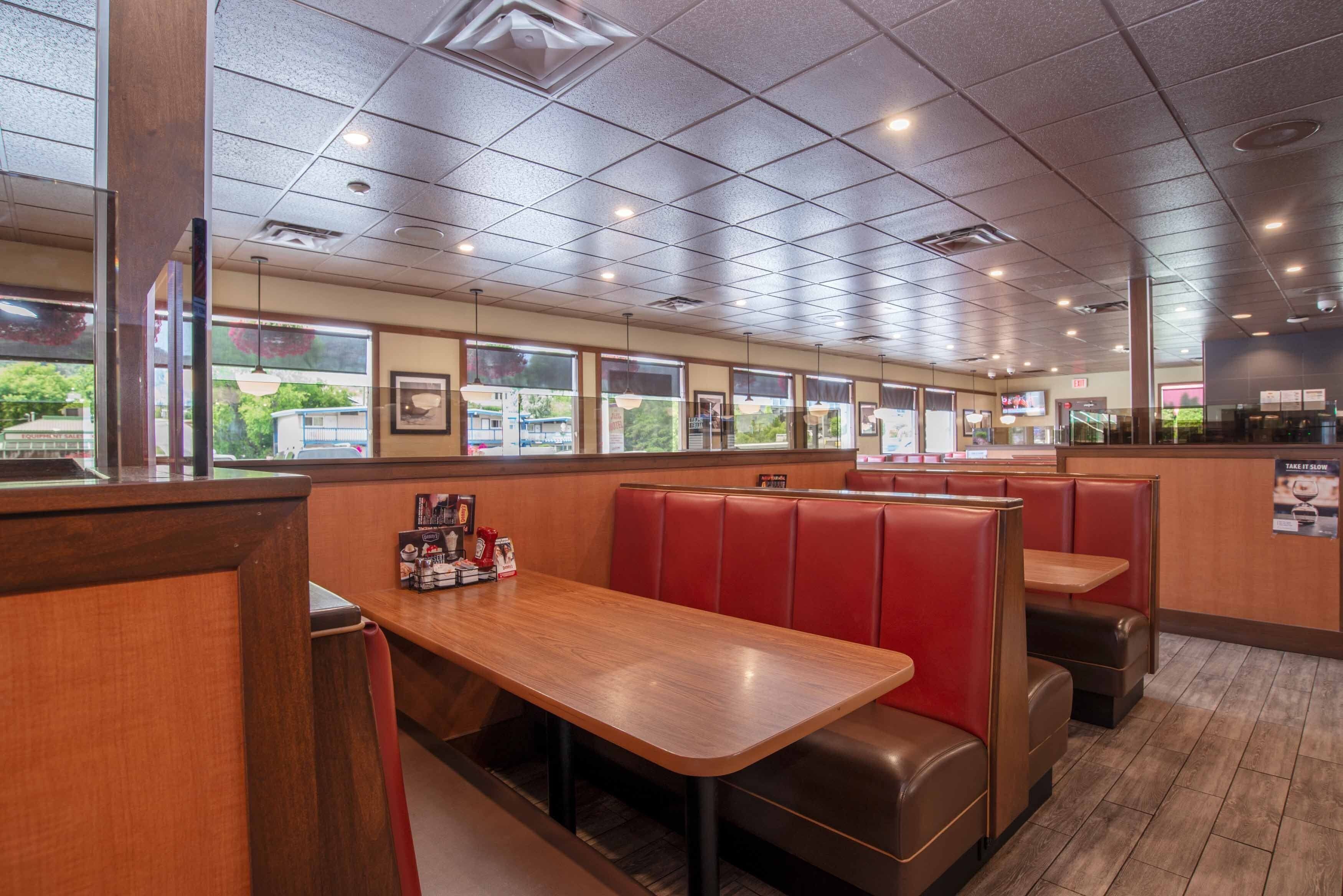 A restaurant interior with booths, tables, and a counter.