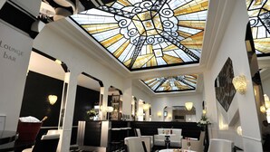 A modern lounge bar with a high ceiling and stained glass design. - Mercure Paris Opéra Faubourg Montmartre (Paris)