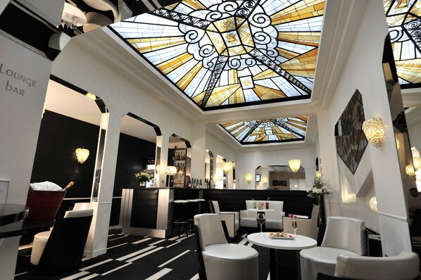 A modern lounge bar with a high ceiling and stained glass design. - Mercure Paris Opéra Faubourg Montmartre (Paris)