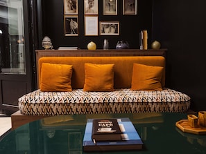 A room with a sofa, a glass table, and framed pictures on the wall. - Mercure Paris Opéra Faubourg Montmartre (Paris)