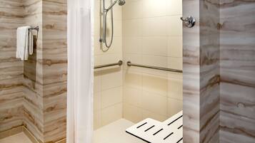 Un espace douche moderne doté d’une porte en verre, d’un porte-serviettes et d’un pommeau de douche.