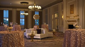 Un hall d’hôtel spacieux, agrémenté d’un magnifique lustre, d’élégants canapés et d’une cheminée.