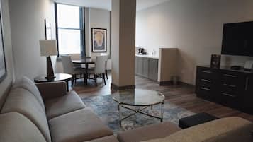 Una sala de estar moderna con un sofá, una mesa de centro y un comedor al fondo.