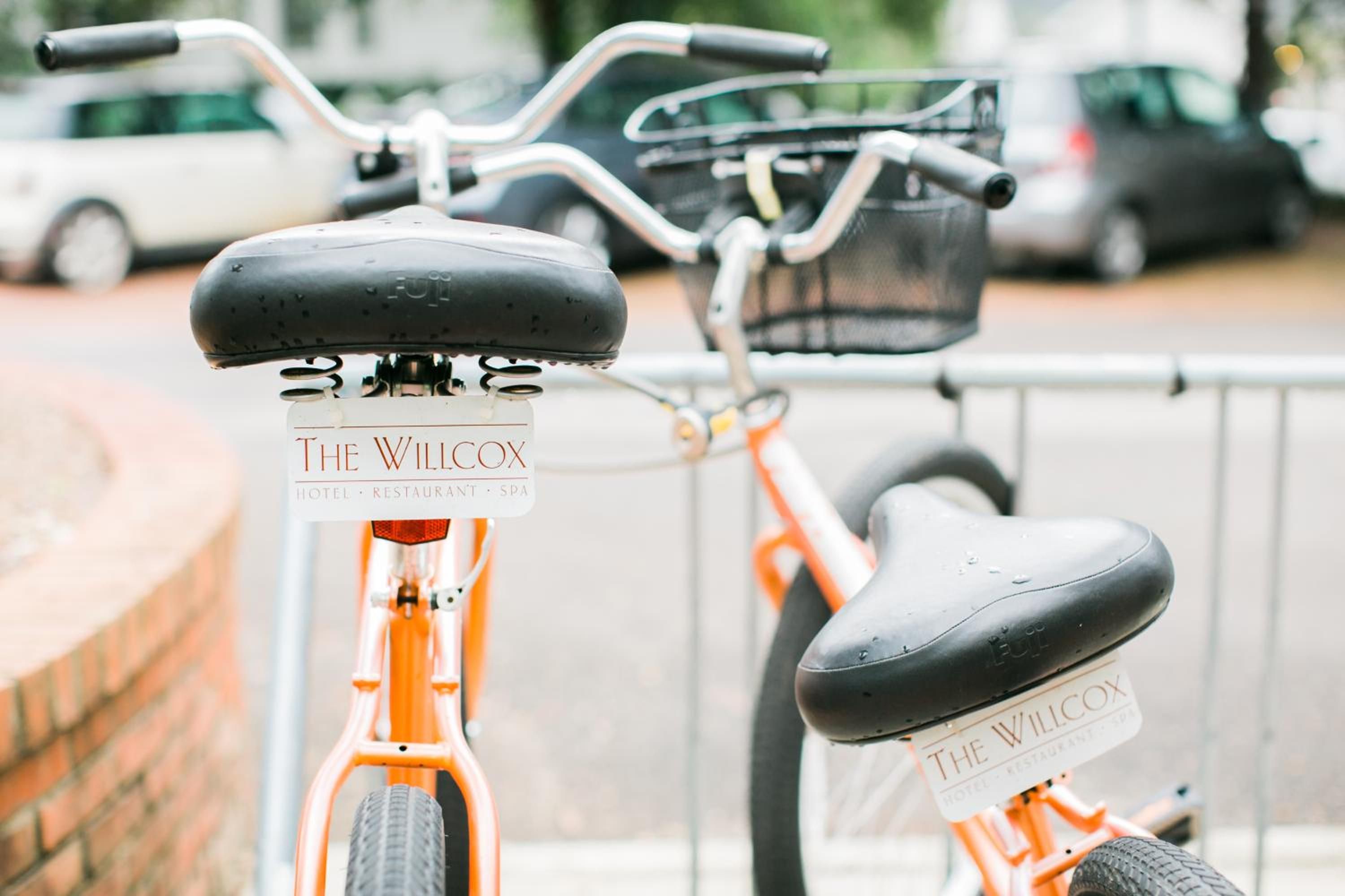 Dos bicicletas con la señalización 'The Wilcox', estacionadas en una acera.