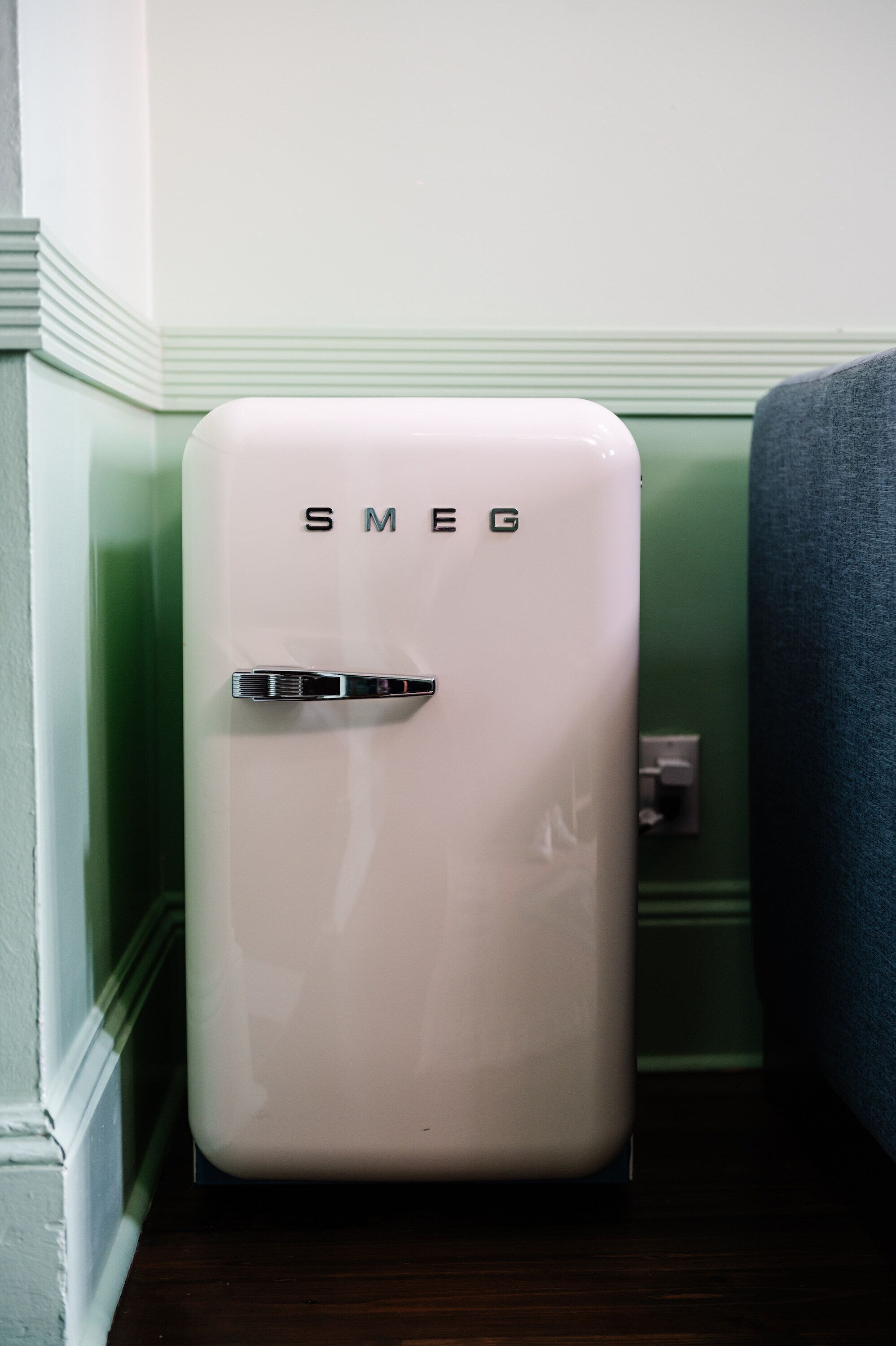 A white, vintage-style refrigerator with the brand name 'SMEG' on the front.
