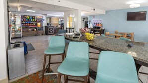 Een moderne bar met een granieten aanrecht, barkrukken en een selectie van snacks en drankjes.