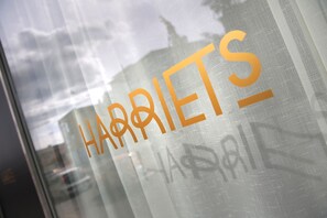 A window with the word "HARRIETS" in orange letters.