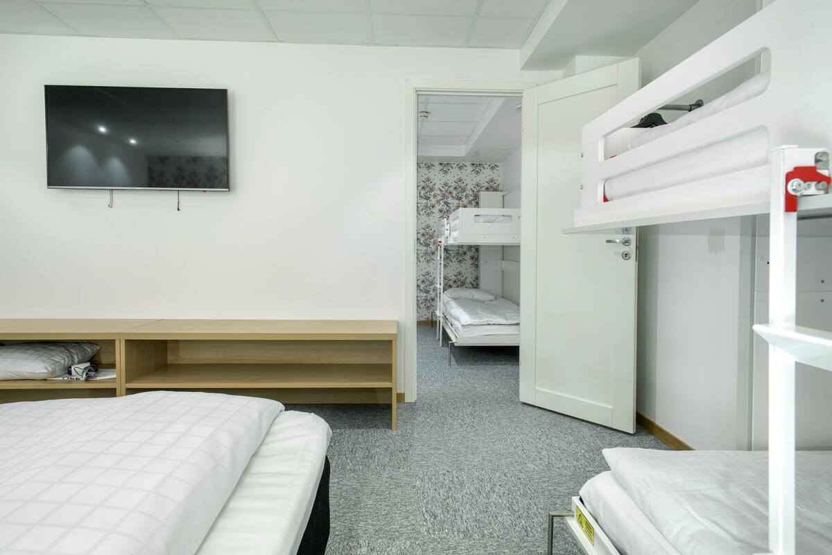 A bedroom with bunk beds, a TV, and a wardrobe.