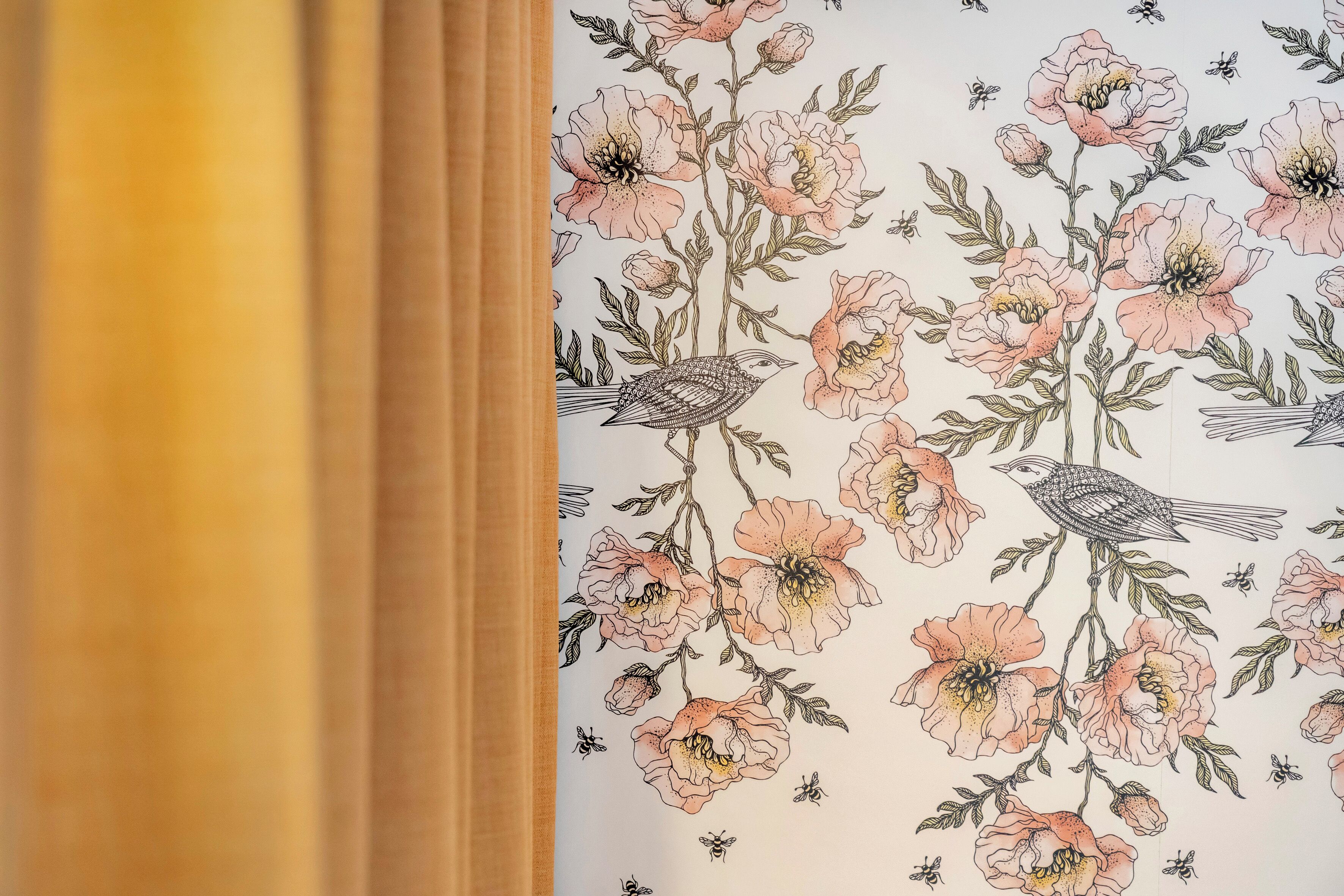 Un papier peint à motifs floraux représentant des oiseaux et des abeilles.