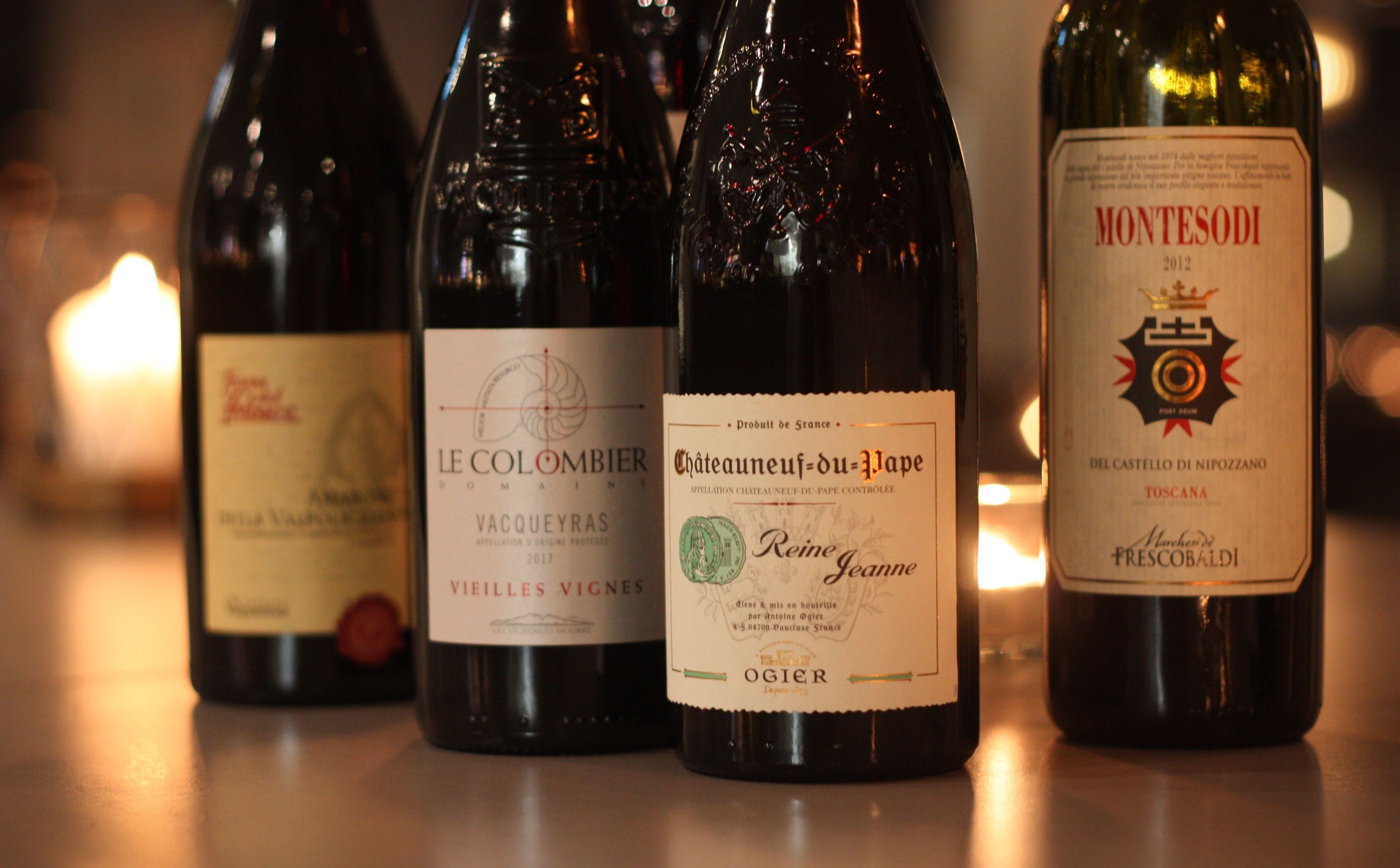 Cuatro botellas de vino sobre una mesa.