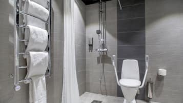 A modern bathroom with a shower, toilet, and towel rack.