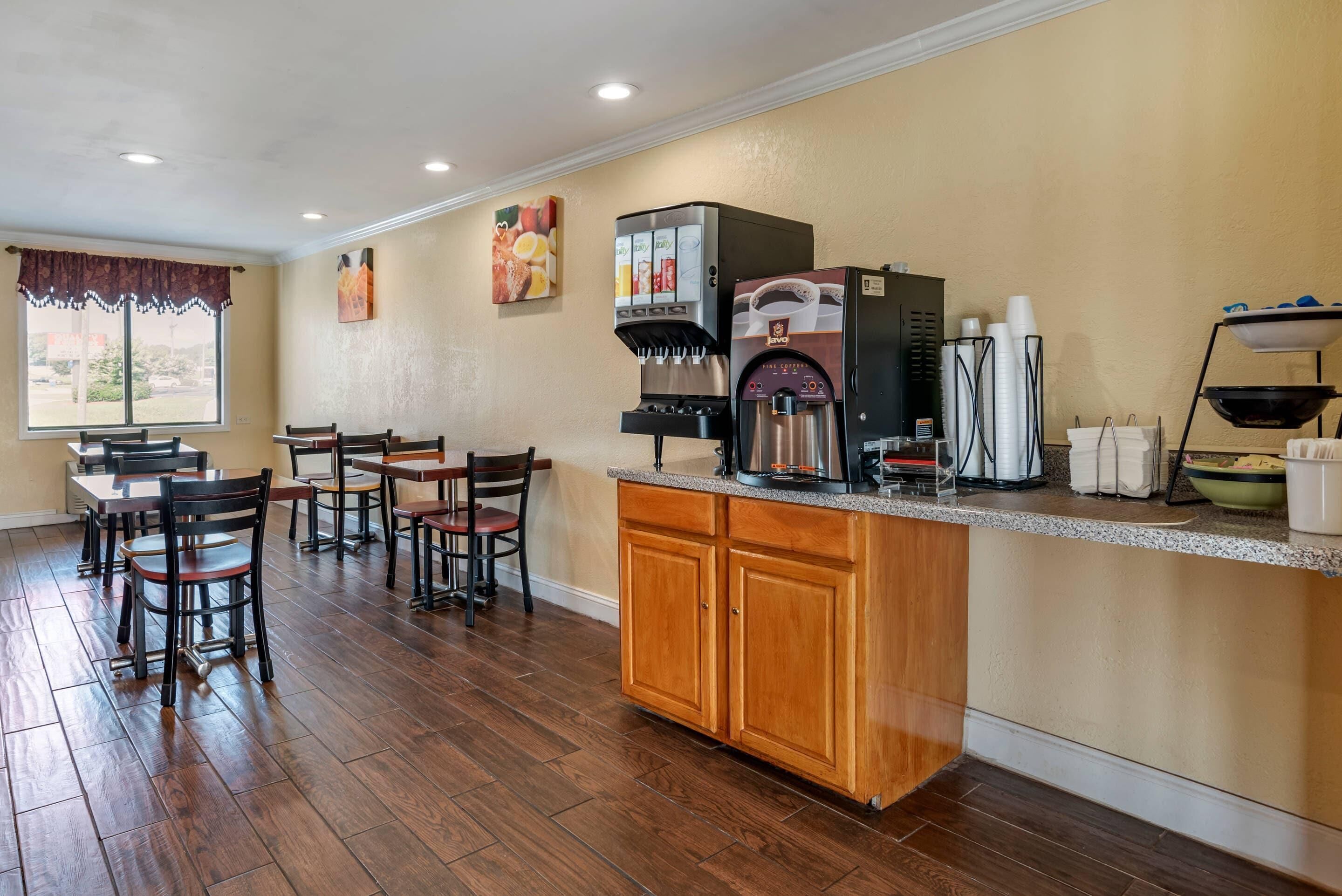 A restaurant with a coffee machine, chairs, and a counter.