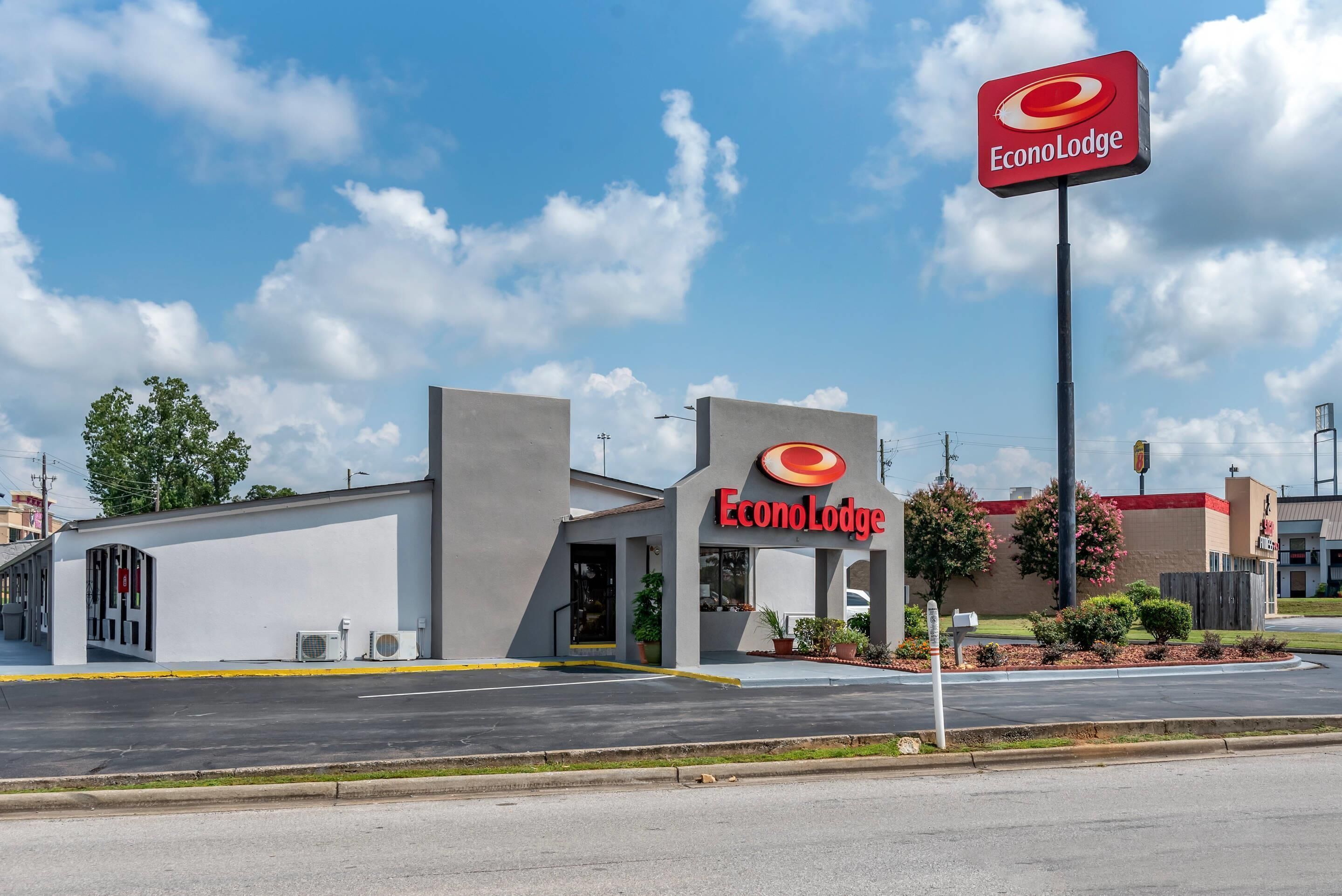 A building with a sign reading 'EconoLodge' and a parking lot in front.