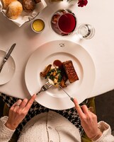 Una mesa con un plato de comida, un tenedor y un cuchillo.