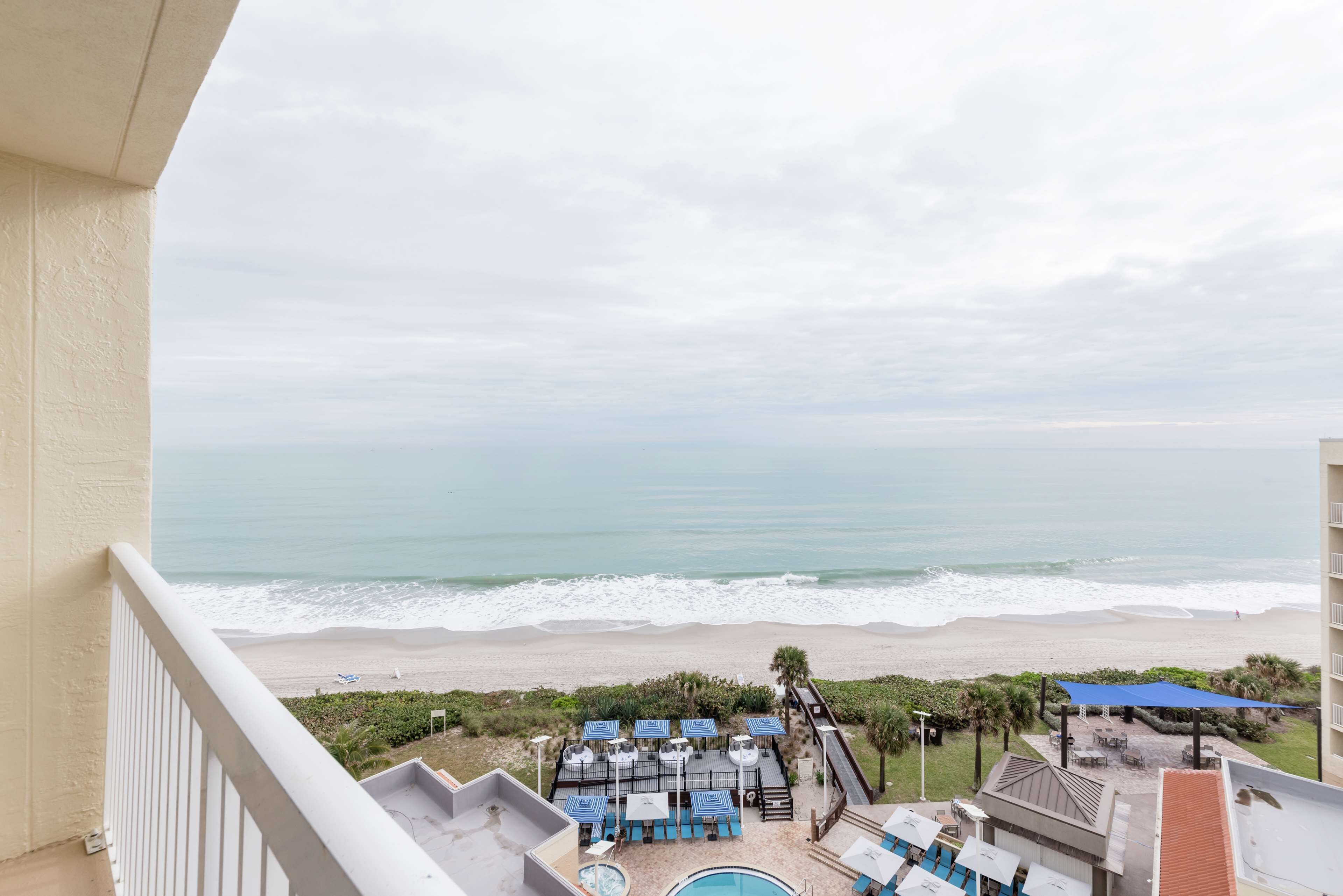 Ein Balkon mit Blick auf Strand und Meer.