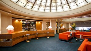 A lobby with a bar area, seating, and a large skylight.
