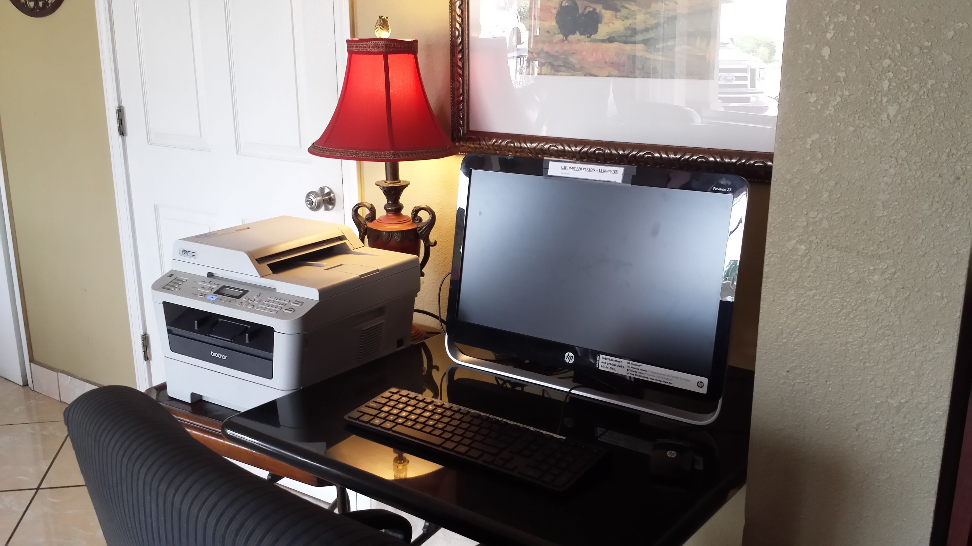 Un bureau avec une imprimante Brother, un écran HP et un clavier.