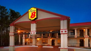A Super 8 motel with a red roof, multiple balconies, and a central entrance.