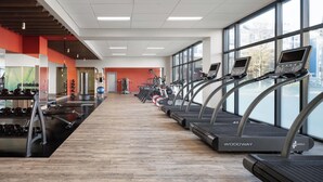 Une salle de sport équipée de tapis de course, de poids et d’appareils d’exercice.
