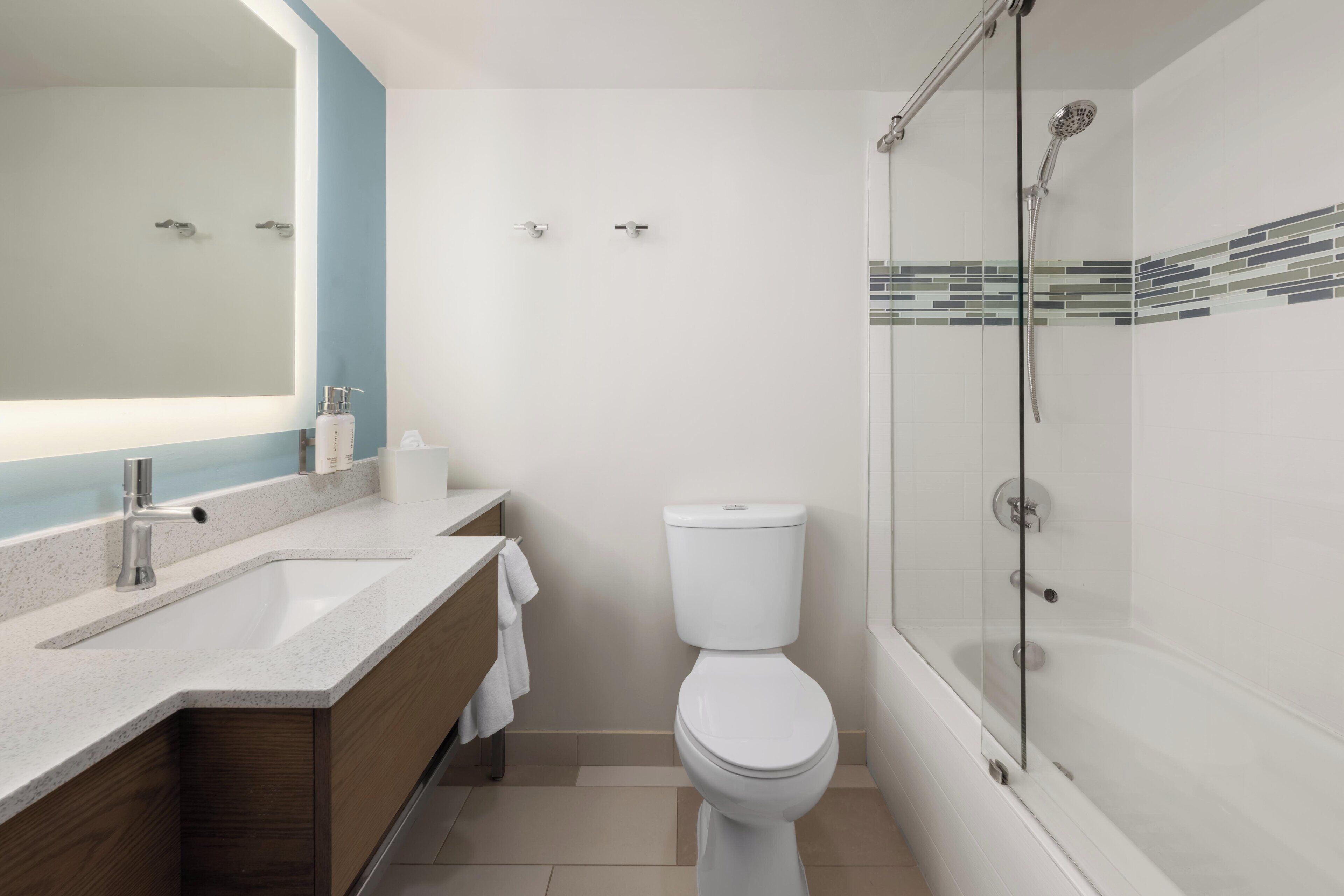 A modern bathroom with a sink, toilet, and glass-enclosed shower.