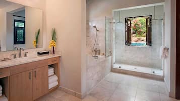 A modern bathroom with a large mirror, two sinks, a shower, and a view of a garden through a window.