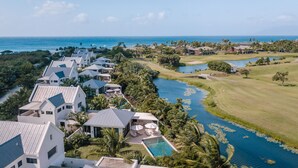 A resort with modern architecture, a swimming pool, and a golf course. - Four Seasons Resort - Nevis (Jessups Village)